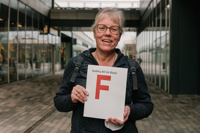 Nancy Burke holds up a sign grading de Blasio: an "F".